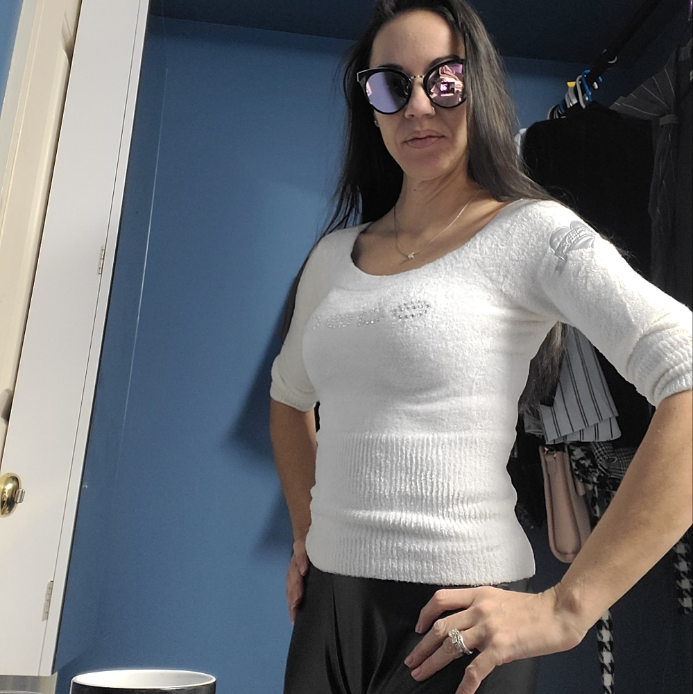 Fuzzy white sweater with rhinestones.